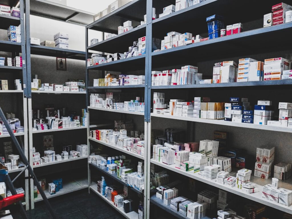 A hand places a prescription pill bottle in a closed, high dresser drawer near a digital thermometer.